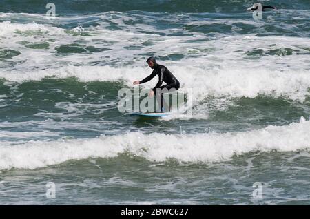 Binz, Germania. 31 maggio 2020. Nils Miller salta con la sua tavola da surf sulle onde nel Mar Baltico. Il vivace vento del nord-est ha portato gioia a surfisti e kite surfisti. Vicino al molo i surfisti stavano aspettando le onde più alte. Escursionisti e bagnanti popolarono anche la spiaggia, che era diventata stretta a causa del vento onshore, a temperature intorno ai 15 gradi. Credit: Stefan Sauer/dpa-Zentralbild/dpa/Alamy Live News Foto Stock