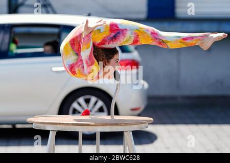 Mannheim, Germania. 31 maggio 2020. Un artista circo mostra trucchi in un drive-in circo del circo dei bambini e dei giovani 'Paletti'. Secondo gli organizzatori, un ampio parcheggio a Mannheim sarà il primo drive-in circense in Germania. Le famiglie passano accanto a varie attrazioni nelle loro auto mentre guidano attraverso il 'paese del circo' con clown, giocolieri, uniciclisti, camminatori tightrope e artisti di trapezio. Credit: Uwe Anspach/dpa/Alamy Live News Foto Stock