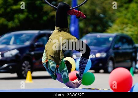 Mannheim, Germania. 31 maggio 2020. Un artista di trapezio mostra trucchi in un circo di guida del circo dei bambini e dei giovani 'Paletti'. Secondo gli organizzatori, un ampio parcheggio a Mannheim sarà il primo drive-in circense in Germania. Le famiglie passano accanto a varie attrazioni nelle loro auto mentre guidano attraverso la 'terra del circo' con clown, giocolieri, uniciclisti, camminatori tightrope e artisti di trapezio. Credit: Uwe Anspach/dpa/Alamy Live News Foto Stock