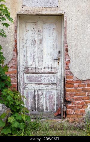 Particolare di un interno abbandonato e rovinato della casa. Vecchia porta di legno. Foto Stock