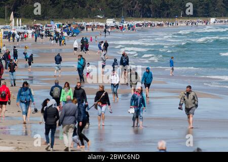 Binz, Germania. 31 maggio 2020. I turisti passeggiano lungo la spiaggia sull'isola di Rügen. Il vivace vento del nord-est ha portato gioia a surfisti e kite surfisti. Vicino al molo i surfisti stavano aspettando le onde più alte. Escursionisti e bagnanti popolarono anche la spiaggia, che era diventata stretta a causa del vento onshore, a temperature intorno ai 15 gradi. Credit: Stefan Sauer/dpa-Zentralbild/dpa/Alamy Live News Foto Stock