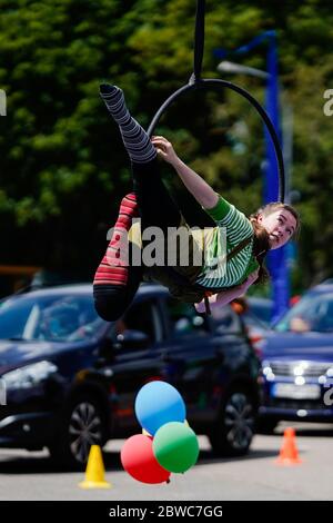 Mannheim, Germania. 31 maggio 2020. Un artista di trapezio mostra trucchi in un circo di guida del circo dei bambini e dei giovani 'Paletti'. Secondo gli organizzatori, un ampio parcheggio a Mannheim sarà il primo drive-in circense in Germania. Le famiglie passano accanto a varie attrazioni nelle loro auto mentre guidano attraverso la 'terra del circo' con clown, giocolieri, uniciclisti, camminatori tightrope e artisti di trapezio. Credit: Uwe Anspach/dpa/Alamy Live News Foto Stock