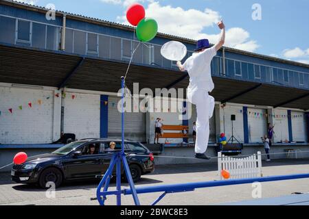 Mannheim, Germania. 31 maggio 2020. Un camminatore tightrope esegue trucchi in un drive-in circo del circo dei bambini e dei giovani 'Paletti'. Un ampio parcheggio a Mannheim diventa il primo drive-in circense della Germania secondo gli organizzatori. Le famiglie passano accanto a varie attrazioni nelle loro auto mentre guidano attraverso la 'terra del circo' con clown, giocolieri, uniciclisti, camminatori tightrope e artisti di trapezio. Credit: Uwe Anspach/dpa/Alamy Live News Foto Stock