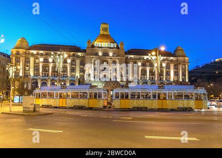 Il tram di Natale passa davanti all'Hotel Gellert all'ora blu Foto Stock