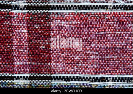 Tessuto colorato di cotone tessuto tappeto. Un frammento di tessuto fatto a mano in rosso. Foto Stock