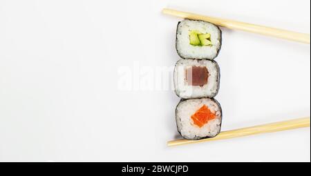 Rotolo di sushi con chisses, con kappa maki cetriolo. Cucina giapponese. Vari sushi e panini con formaggio di pesce e chuka insalata in bastoncini isolati su sfondo bianco Foto Stock