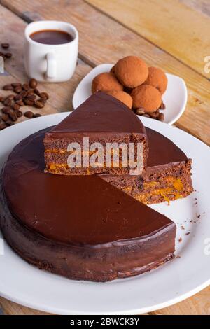 torta al tartufo con caffè, colazione sana. Marmellata di pesche su tavolo di legno. Foto verticale Foto Stock