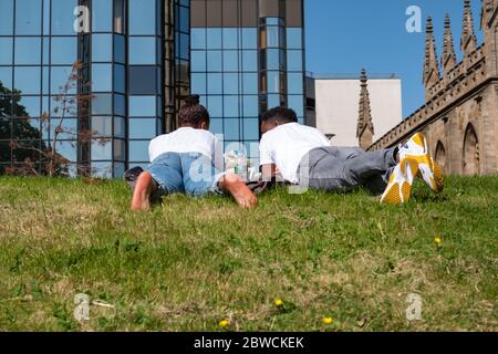 Glasgow, Scozia, Regno Unito. 31 maggio 2020. Una coppia che si trova sull'erba di Clyde Street in un caldo e soleggiato pomeriggio di domenica. Il governo scozzese ha annunciato il 28 maggio un allentamento delle regole di blocco del coronavirus. Credit: Notizie dal vivo SKULLY/Alamy Foto Stock