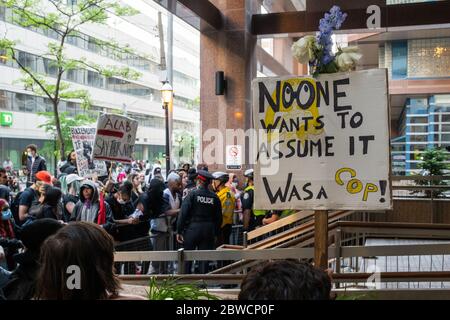 I manifestanti urlano mentre gli ufficiali di polizia si levano tranquillamente contro una protesta 'Not another Black Life' dopo la morte di Regis Korchinski-Paquet a Toronto. Foto Stock