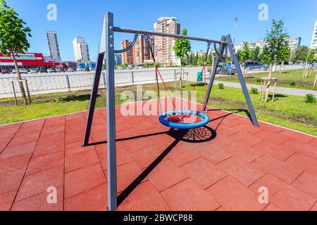 Samara, Russia - 29 maggio 2020: Parco giochi per bambini per bambini nel nuovo quartiere con swing per giocare e riposare. Luogo di ricreazione con swing in città Foto Stock