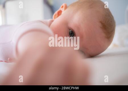 Cute baby girl in piedi a letto fare facce divertenti, faccia arrabbiata, piangendo al mattino Foto Stock