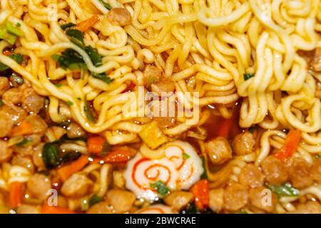 Tagliatelle istantanee cotte con spezie, verdure secche e carne liofilizzata. Primo piano Foto Stock