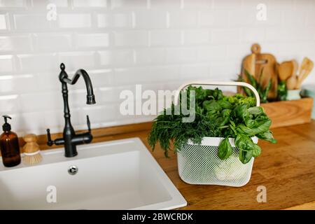 Insalate fresche ed erbe in cesto di metallo sul tavolo in cucina. Concetto di shopping senza sprechi. Vita sostenibile Foto Stock