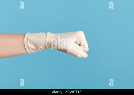 Profilo Vista laterale primo piano della mano umana in guanti chirurgici bianchi che mostrano pugni di pugilato con la mano. Attacco o difesa contro problemi. Interno, studio sh Foto Stock