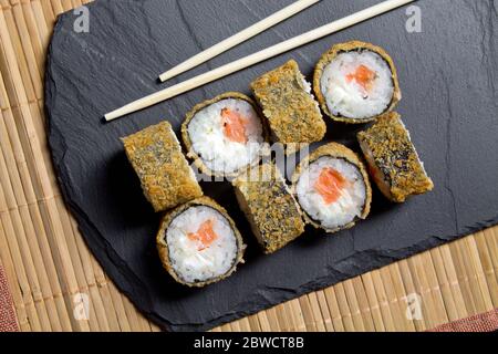 Sushi roll tempura con gamberi sullo sfondo dei tappetini. Vista dall'alto del sushi. Foto del sushi food per il menu. Foto Stock