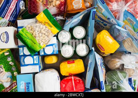 San Pietroburgo, Russia - 26 marzo 2020: Diversi prodotti sul tavolo dopo grandi acquisti da ipermercato con marchi. Vista dall'alto Foto Stock