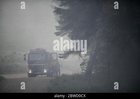 Maesteg, Galles, 31 maggio 2020. Il personale del servizio antincendio lavora fino a tarda sera per combattere un grande incendio nella foresta a Maesteg, nel Galles del Sud. Gli equipaggi di tutta la regione e un elicottero hanno preso le fiamme per 24 ore per portarle sotto controllo mentre diversi incendi infuriavano in tutta la zona: Ha portato alla fine del maggio più arido da quando i record sono iniziati 124 anni fa. Credit : Robert Melen/Alamy Live News. Foto Stock