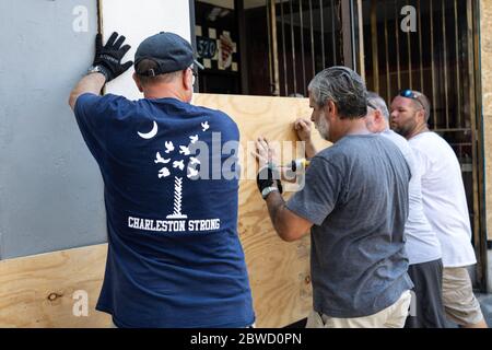 Charleston, Stati Uniti. 31 maggio 2020. I volontari aiutano a salire a bordo di un negozio lungo il quartiere dello shopping di King Street dopo una protesta sulla morte di George Floyd, che è diventata violenta e distruttiva il 31 maggio 2020 a Charleston, Carolina del Sud. Floyd è stato soffocato a morte dalla polizia a Minneapolis, causando proteste in tutta la nazione. Credit: Richard Ellis/Alamy Live News Foto Stock