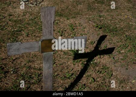 Una croce di legno gettando un'ombra al cimitero di Norwood Ovest il 30 maggio 2020 a Londra Sud nel Regno Unito. Foto di Sam Mellish Foto Stock