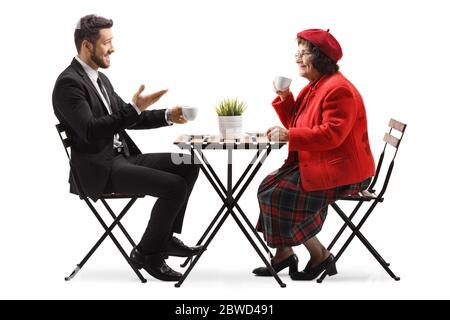 Giovane uomo in tuta seduto in un bar con una donna anziana e parlando isolato su sfondo bianco Foto Stock