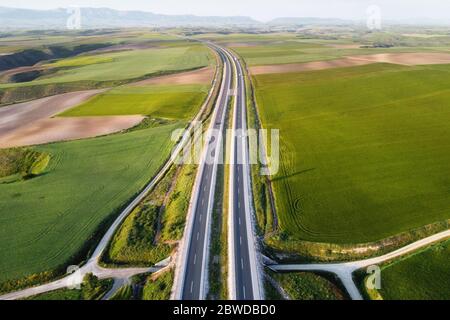 Vista aerea di una strada con auto e camion, in un bellissimo paesaggio di campagna. Foto Stock