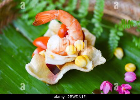 insalata di gamberi mais e salsa su cracker di gamberi con sfondo di foglie di banana cibo asiatico in tailandese / delizioso menu gamberetti gamberetti cucinati Foto Stock