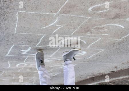 Giochi per bambini hopscotch su parco giochi all'aperto, attività all'aperto per bambini. Foto Stock