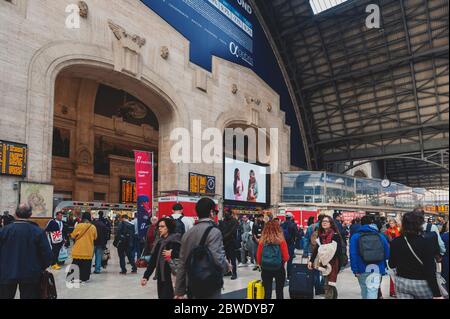 Una folla di passeggeri in treno che arrivano alla sala arrivi di Milano Centrale, la principale stazione ferroviaria della città di Milano in Italia Foto Stock