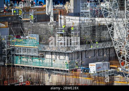 I lavoratori edili restano socialmente distanziati mentre lavorano su rinforzi in acciaio presso la centrale nucleare di Hinkley Point C vicino a Bridgwater, Somerset, il più grande cantiere d'Europa, dove stanno completando un getto di calcestruzzo nella base del reattore nucleare dell'unità 2. Foto Stock