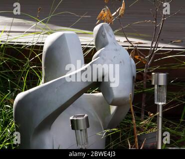 Madre allevando bambino giardino scultura con giardino solare luci con retroilluminazione Foto Stock