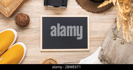 set di accessori per viaggi estivi e lavagna su tavolo di legno con spazio per la copia Foto Stock