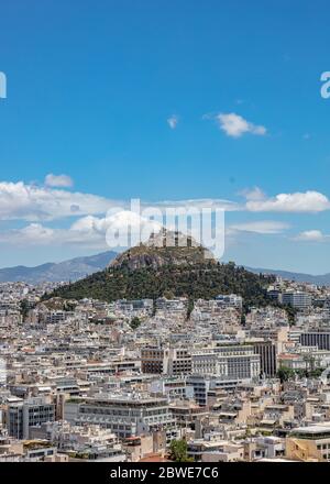 Foto aerea del Monte Licabetto e del paesaggio urbano di Atene, vista dalla collina dell'Acropoli in Grecia. Cielo blu con nuvole, sole primavera giorno. Foto Stock