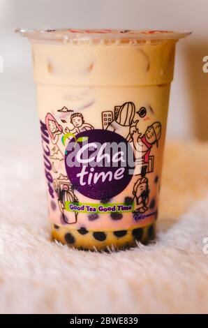 Un editoriale illustrativo della bevanda a base di tè al latte fresco Brown Sugar della catena Chata con vista laterale del logo. Foto Stock