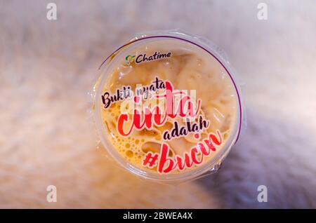 Un editoriale illustrativo del tè al latte fresco Brown Sugar della franchising Chatime con una vista dall'alto della frase scritta in bahasa indonesia Foto Stock