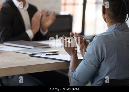 Primo piano dipendente afro-americano che si batte le mani durante la riunione aziendale Foto Stock