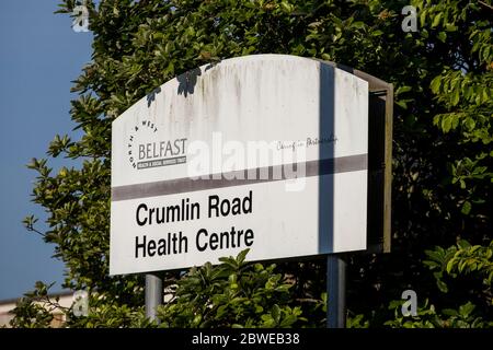 Un segno del Crumlin Road Health Center, che ha un centro di test Covid-19 su di esso??? S terreni accanto al Tribunale di Crumlin Road, dove i vigili del fuoco del servizio di soccorso e antincendio dell'Irlanda del Nord hanno affrontato un grande incendio all'interno del tribunale di Belfast, Irlanda del Nord. Foto Stock