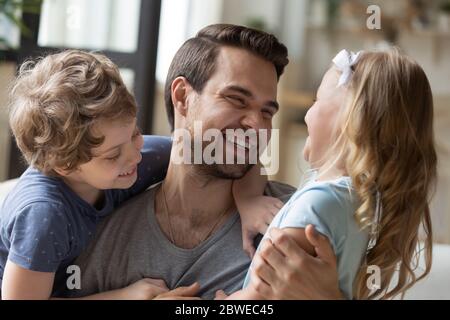 Il giovane papà con grande gioia si diverte a giocare con i bambini piccoli Foto Stock