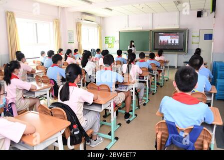 Pechino, Cina. 1 Giugno 2020. Gli studenti guardano un video chiamato la prima classe di questo semestre in una classe in Shuangyushu No. 1 Scuola primaria a Pechino, capitale della Cina, 1 giugno 2020. Gli studenti al primo e secondo grado di scuole superiori, al primo e al secondo grado di scuole superiori e al sesto grado di scuole elementari sono tornati a scuola per questo semestre a Pechino lunedì. Credit: Ren Chao/Xinhua/Alamy Live News Foto Stock