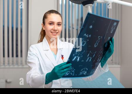 Una dottoressa che esamina un'immagine radiografica Foto Stock