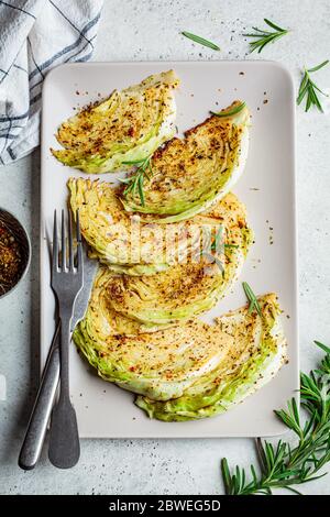 Bistecche di cavolo al forno con spezie su un piatto grigio. Concetto di cibo vegano sano. Foto Stock