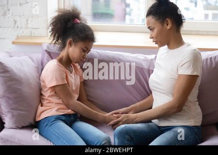 Madre e figlia africane tengono le mani con una conversazione riservata Foto Stock