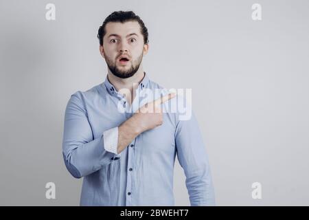 Bell'uomo è sorpreso e mostra le mani al fianco Foto Stock