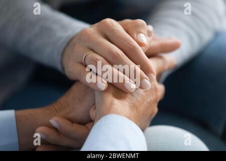 Figlia adulta che tiene le mamme mano vicino immagine Foto Stock