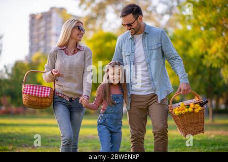 Buona famiglia che ha picnic nel parco.giovane famiglia felice di tre divertirsi insieme.divertimento della famiglia fuori. Foto Stock