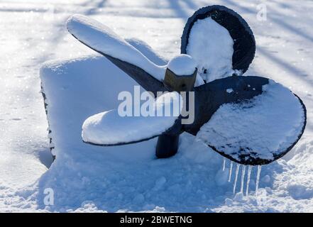 Primo piano di un'opera d'arte fatta di elica sepolta della nave che si stacca dalla riva della neve in inverno . Finlandia Foto Stock