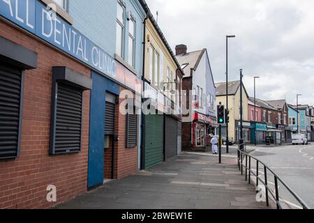 Sheffield UK – Aprile 09 2020: Una donna solista cammina per le strade vuote di Darnall durante il blocco del Coronavirus Covid-19 a Staniford Road Foto Stock