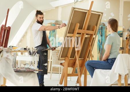 Ritratto di artista con porticata maschile ritratto di giovane donna in studio, copia spazio Foto Stock
