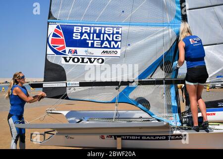 Gli atleti di Tokyo 2020 Charlotte Dobson, a sinistra, e Saskia Tidey, a destra, si preparano e preparano il loro 49er FX per una sessione di allenamento mentre i membri del Team GB a Weymouth e Portland National Sailing Academy tornano ad allenarsi in acqua a coppie, come restrizioni di blocco in Inghilterra. Foto Stock