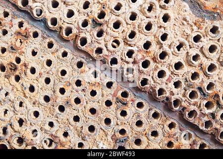 Foglio di tubo o piastra di scambiatore di calore o di struttura di closeup caldaia sfondo macro diagonale pieno di depositi minerali duri insolubili scala di sali, e cor Foto Stock