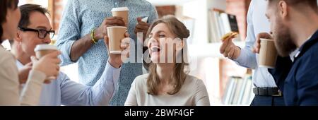 Gruppo di allegri colleghi mangiano caffè con pizza drink durante la pausa Foto Stock